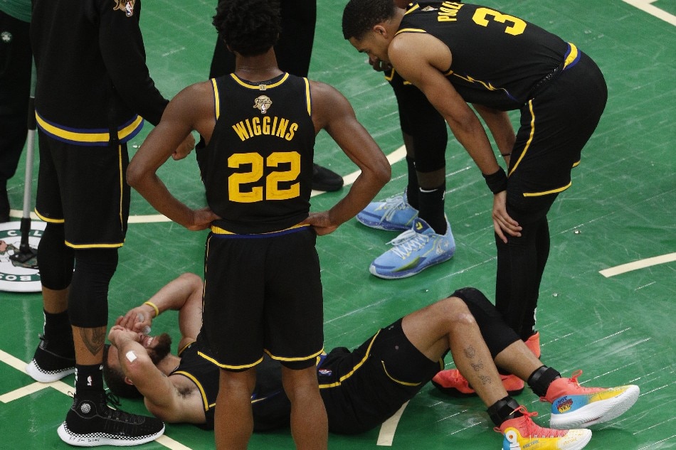 Golden State Warriors guard Stephen Curry (C, bottom) reacts after a play when Boston Celtics center Al Horford landed on his foot during the second half of Game 3 of the NBA Finals at the TD Garden in Boston, Massachusetts, USA, 08 June 2022. Amanda Sabga, EPA-EFE