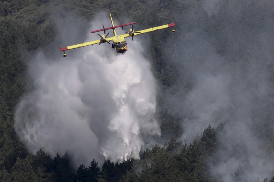 A firefighting aircraft drops water on a forest fire that started the previous night in Sierra de Leyre , Navarra region, Spain, on June 15, 2022. Jesus Diges, EPA-EFE