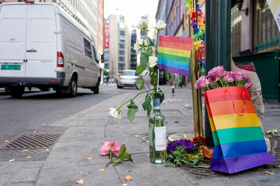 Flowers and rainbow flags sit on the street after several shots were fired by a gunman outside the London Pub, a gay bar and nightclub, in the center of Oslo, Norway on June 25, 2022. Terje Pedersen/EPA-EFE