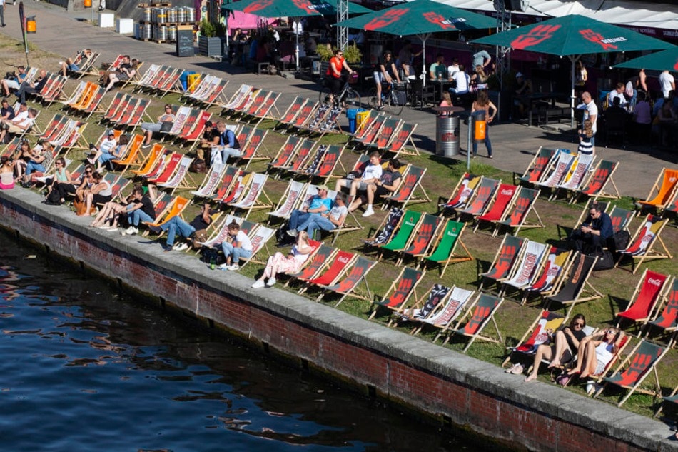 People relax in beach chairs along the banks of the Spree river in Berlin, June 22, 2022. Katharina Hesse, EPA-EFE