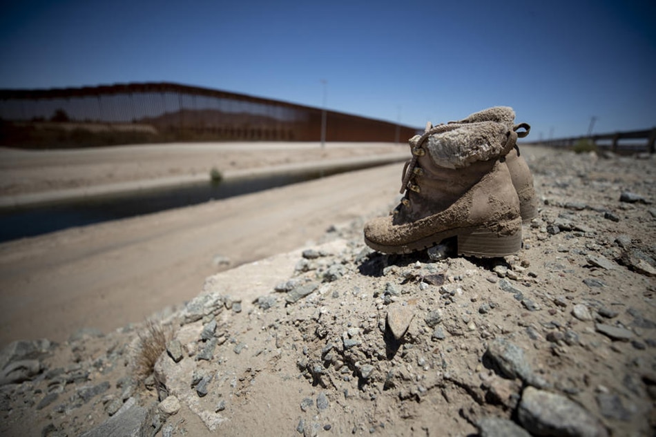 Muddy shoes are abandoned in front of the wall near the border between Mexico and the US in Yuma, Arizona, USA, on June 20, 2022. Etienne Laurent, EPA-EFE/file 