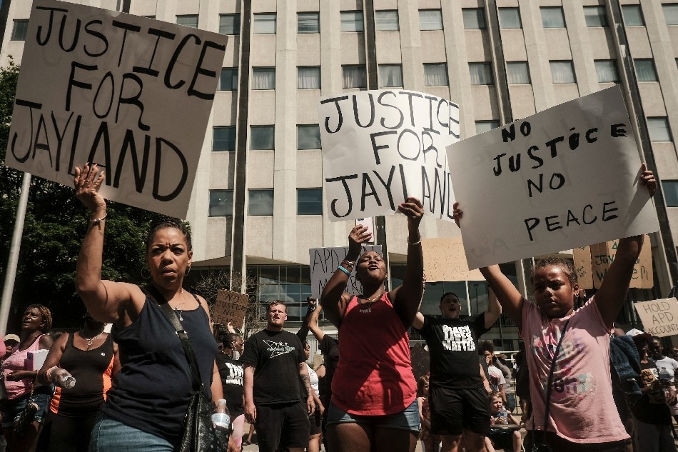 Demonstrators hold 'Justice for Jayland' signs as they gather outside Akron City Hall to protest the killing of Jayland Walker, shot by police, in Akron, Ohio, July 3, 2022. Several hundred protesters marched Sunday in Akron, Ohio after the release of body camera footage that showed police fatally shooting a Black man with several dozen rounds of bullets. As anger rose over the latest police killing of a Black man in the United States, and authorities appealed for calm, a crowd marched to City Hall carrying banners with slogans such as 'Justice for Jayland.' Matthew Hatcher / AFP