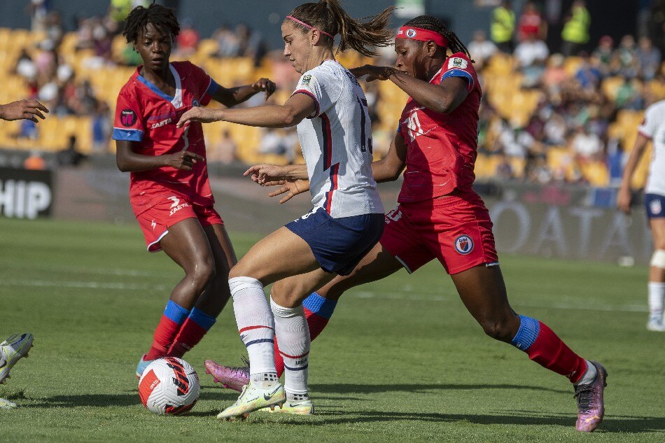 Alex Morgan (C) of the USA in action against Kethna Louis (R) of Haiti during the 2022 CONCACAF Women's Championship group A soccer match between USA and Haiti, at the University Stadium in San Nicolás de los Garza, Mexico, 04 July 2022. Miguel Sierra, EPA-EFE