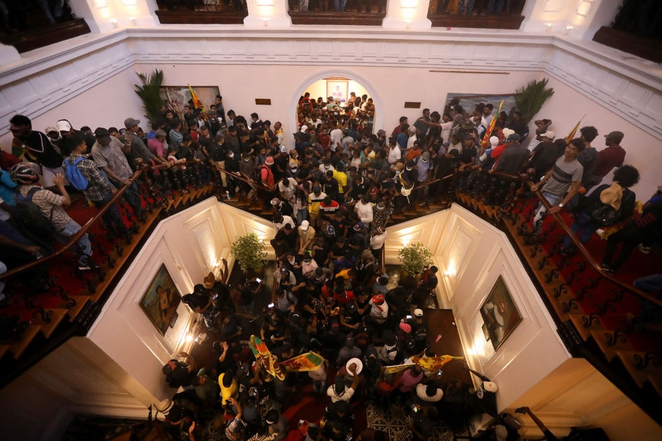 People arrive inside the president's official residence during the anti-government protest in Colombo, Sri Lanka on Saturday. Protests have been rocking the country for over three months, calling for the resignation of the president and prime minister over their alleged failure to address the economic crisis. Chamila Karunarathne, EPA-EFE