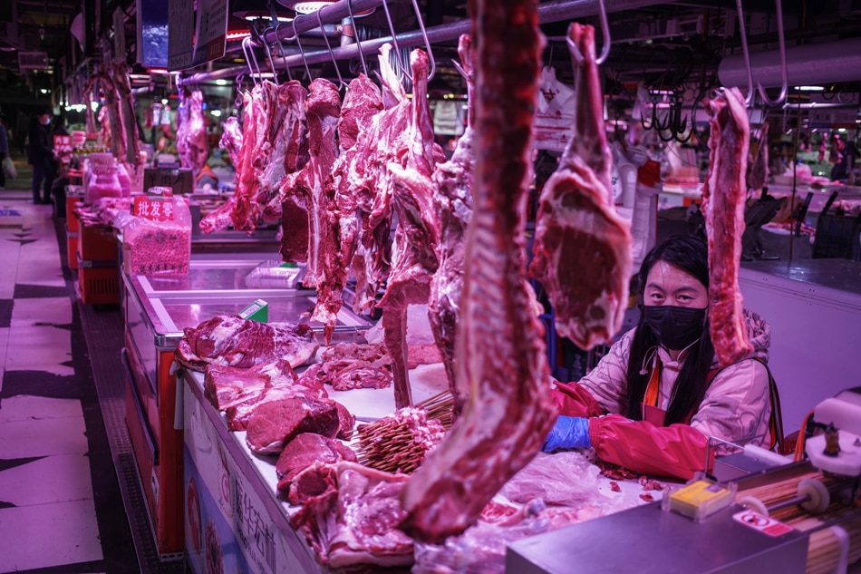 A vendor waits for buyers at her meat stall at a market in Beijing, China, March 9, 2022. According to the National Bureau of Statistics, China's Consumer Price Index (CPI), which is a main gauge of inflation, rose 0.9 percent year-on-year in February. Wu Hong, EPA-EFE