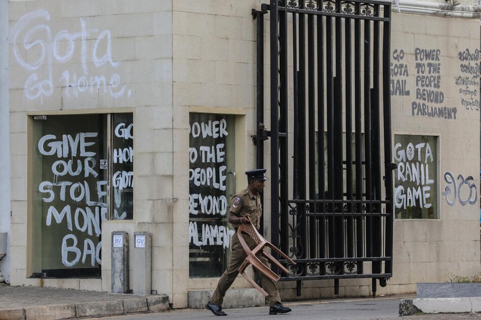 A police officer walks past anti-government slogans written on a wall near the President's House following the resignation of Gotabaya Rajapaksa as president, in Colombo, Sri Lanka, July 15, 2022. Chamila Karunarathne, EPA-EFE