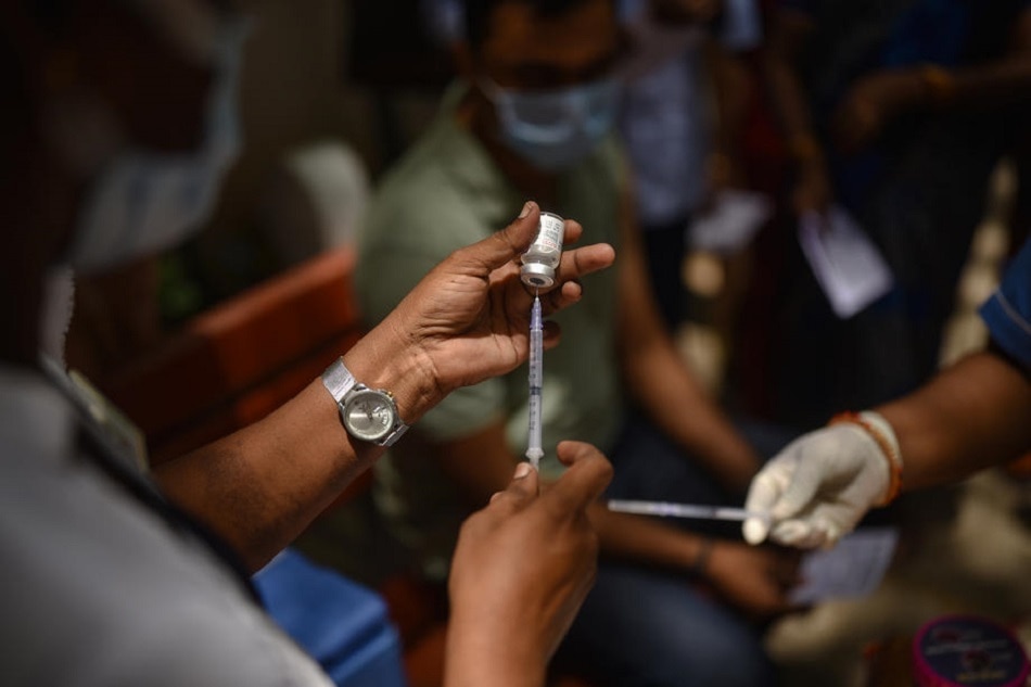 An Indian health worker prepares to administer a free booster shot of the COVID-19 vaccine to a man during a 75-day free booster dose vaccination drive, at a government health centre, in Chennai, India, July 15, 2022. Idrees Mohammed, EPA-EFE
