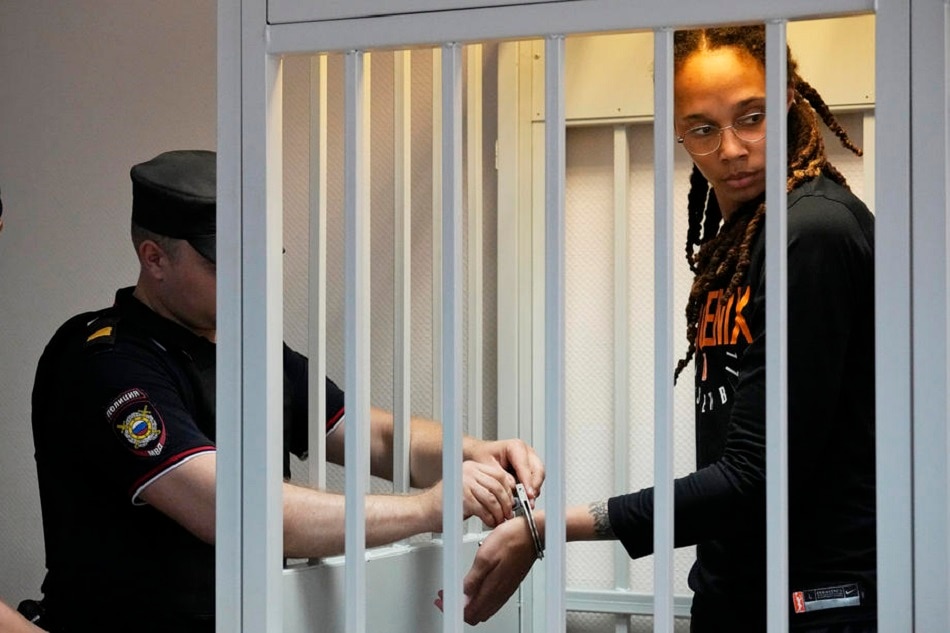 A policeman removes the handcuffs from Brittney Griner in a courtroom prior to a hearing at the Khimki City Court outside Moscow, July 27, 2022. Alexander Zemlianichenko, EPA-EFE/pool/file