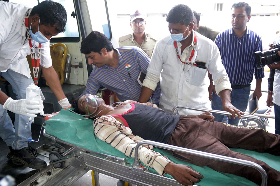 A patient in an ambulance as he is carried for a treatment after drinking poisonous liquor at a city hospital in Ahmedabad, Gujarat, India, July 26, 2022. At least 40 people have died after consuming illegal alcohol in Gujarat