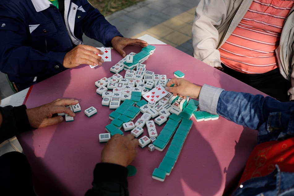 Chinese elder people gather to play mahjong in the street of Beijing, China, Oct. 10, 2019. Wu Hong, EPA-EFE/File 
