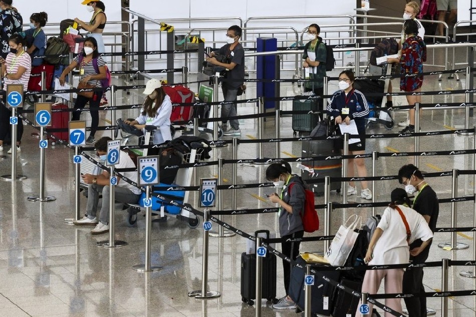 Arrivals at Hong Kong’s airport wait to be taken to their quarantine hotels. Photo: K. Y. Cheng, South China Morning Post