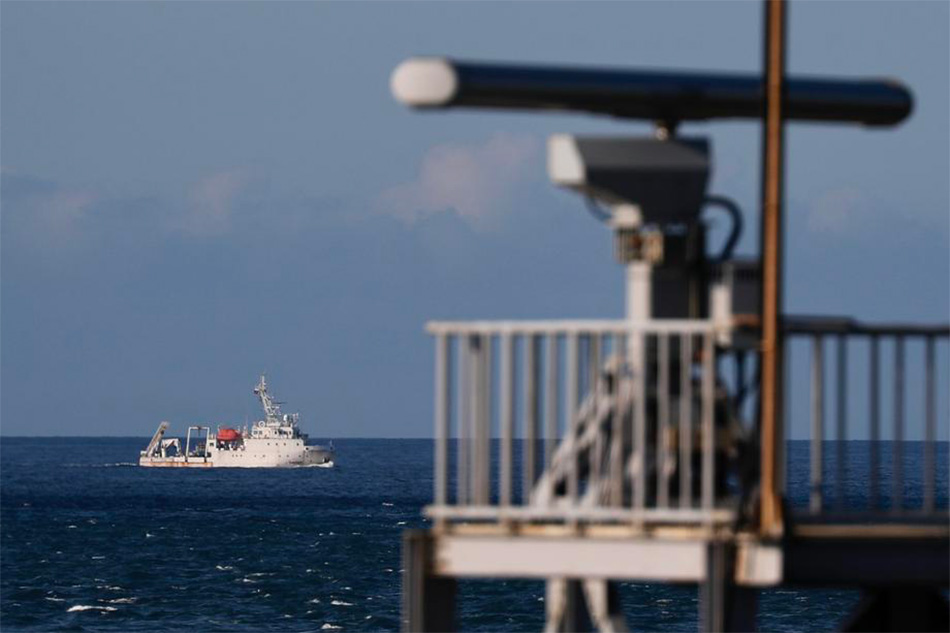A marine vessel maneuvers past a radar tower as it sails away from the location where the Chinese military believed to conduct a live fire drill, is seen from the coast of New Taipei city, Taiwan