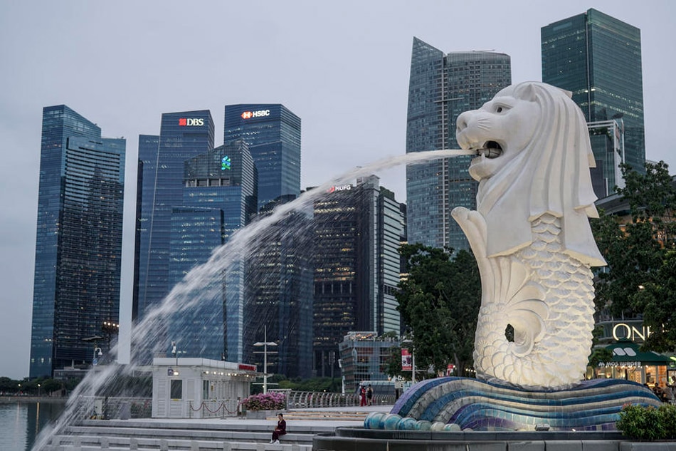 A woman is dwarfed by the Merlion statue and buildings of the financial district in Singapore, July 14, 2021. According to the Ministry of Trade and Industry, Singapore's economy grew by 14.3 percent in the second quarter of 2021 year-on-year. This is attributed to the fall in the GDP last year due to circuit breaker measures implemented at the height of the COVID-19 coronavirus pandemic in Singapore from April until June 2020. Wallace Woon, EPA-EFE 