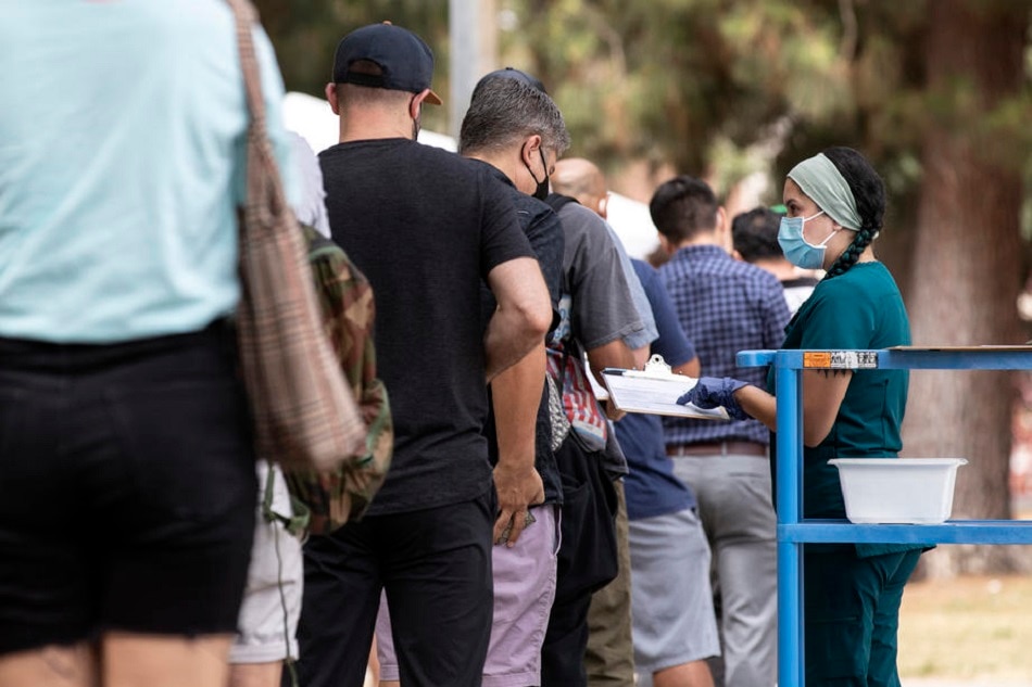 A nurse distributes forms for patients to fill out as more than a hundred people wait in line to get a monkeypox vaccine, at Obregon Park, in Los Angeles, August 4, 2022. Etienne Laurent, EPA-EFE/file