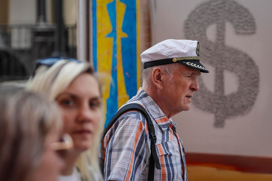 Russians walk past paintings for sale in Moscow, Russia, August 10, 2022. Yuri Kochetkov, EPA-EFE/File
