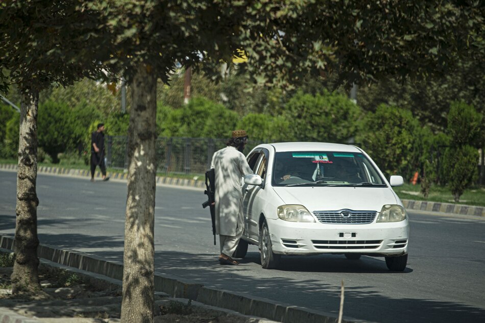 A Taliban fighter speaks with the driver of a car near the Russian embassy after a suicide attack in Kabul on September 5, 2022. A suicide bomber struck near the Russian embassy in the Afghan capital on September 5, killing two staff from the diplomatic mission and wounding several other people, the foreign ministry in Moscow said. Wakil KOHSAR/AFP