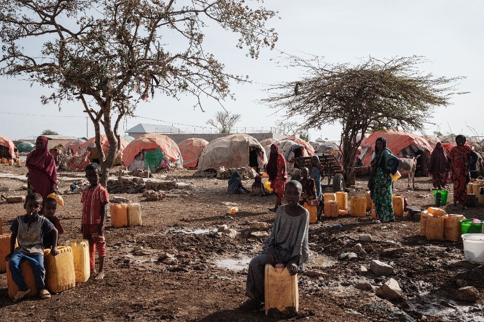 In this file photo taken on Feb. 13, 2022 People wait for water with containers at a camp, one of the 500 camps for internally displaced persons (IDPs) in town, in Baidoa, Somalia. UN humanitarian chief Martin Griffiths warned on September 5, 2022 that Somalia was 'at the door of famine' after being hit by 4 failed rainy seasons that has caused a devastating drought. Yasuyoshi Chiba, AFP
