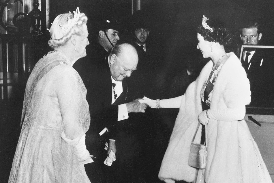 Prime Minister Winston Churchill kisses on April 4, 1955 Queen Elizabeth II's hand, as she leaves 10 Downing Street in London, after a dinner given by Churchill. STF/AFP/file