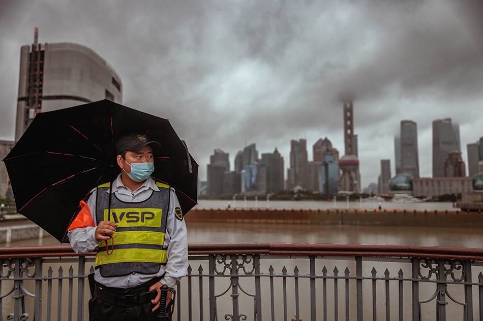 A security guard stands on a bridge during a rainy day as typhoon Muifa is expected to make landfall, in Shanghai, China, 14 September 2022. EPA-EFE/ALEX PLAVEVSKI