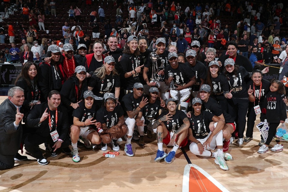 The Las Vegas Aces pose with the 2022 WNBA Championship Trophy after Game 4 of the 2022 WNBA Finals on September 18, 2022 at Mohegan Sun Arena in Uncasville, Connecticut. Chris Marion, NBAE via Getty Images/AFP