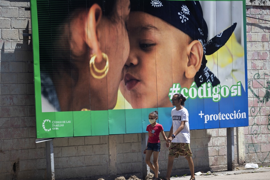 A man and a child walk past a banner that is part of the 'Yes' campaign in the referendum on the family code, in Havana, Cuba 24 September 2022. More than eight million Cubans are called on 25 September to participate in the referendum on the legislative package that opens the possibility of approving same sex marriage, adoption by same sex couples and 'solidarity' pregnancy, among other issues. EPA-EFE/Yander Zamora