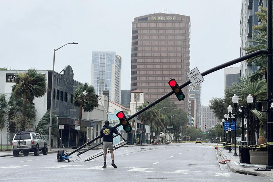 A man walks on Orange Avenue amidst downed traffic lights following Hurricane Ian, in Orlando, Florida, September 29, 2022. Gary Bogdon, EPA-EFE