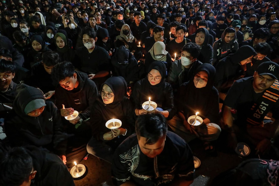 People hold candles during a mass prayer for the victims of the Kanjuruhan Stadium stampede in Malang, East Java, Indonesia, October 5, 2022. Mast Irham, EPA-EFE