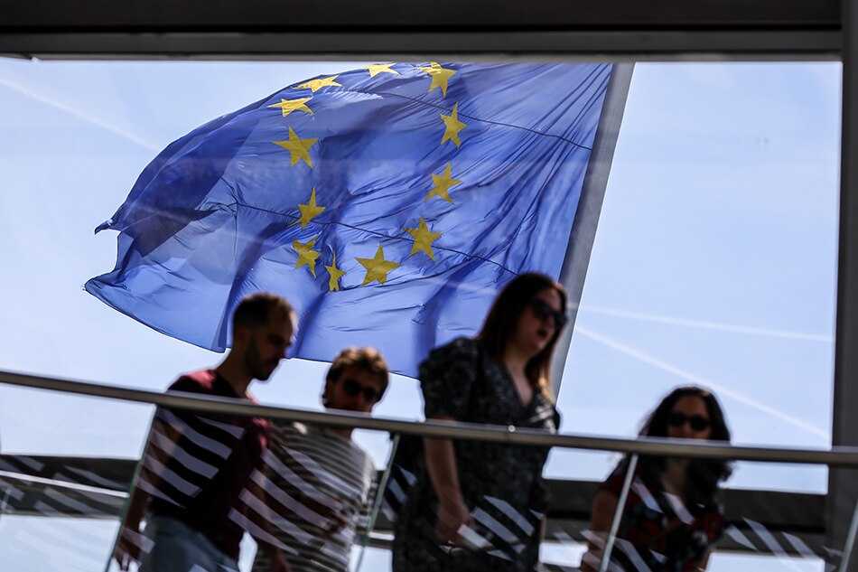 Le drapeau de l'Union européenne (UE) flotte au vent alors que les visiteurs passent devant le dôme de l'observatoire du Reichstag à Berlin, Allemagne, le 19 mai 2022. EPA-EFE/OMER MESSINGER