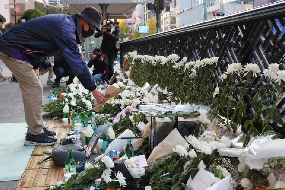 A person offers flowers at a temporary mourning space near the scene of a tragic Halloween stampede in Itaewon district, Seoul, South Korea, Oct. 31, 2022. The accident claimed 154 lives, including 26 foreigners. EPA-EFE/Yonhap 