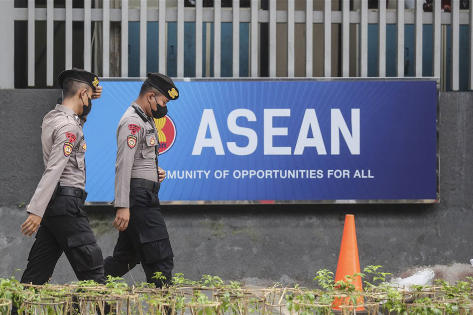 Police officers walk past the Association of Southeast Asian Nations (ASEAN) logo outside the ASEAN secretariat as vehicles of the delegates enter the compound ahead of the special ASEAN foreign ministers' meeting in Jakarta, Indonesia, Oct. 27, 2022. The ASEAN foreign ministers special meeting is being held to discuss the ongoing crisis in Myanmar. Bagus Indahono, EPA-EFE