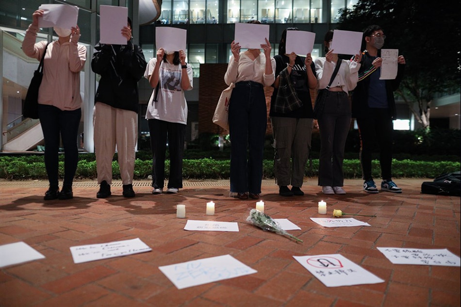 Mainland Chinese students hold sheets of blank paper during a vigil for the victims of China’s zero-COVID policy and the victims of the Urumqi fire at the University of Hong Kong on November 19, 2022. Protests against China's strict COVID-19 restrictions have erupted in various cities including Beijing and Shanghai, triggered by a tower fire that killed 10 people in Xinjiang’s capital, Urumqi. Jerome Favre, EPA-EFE