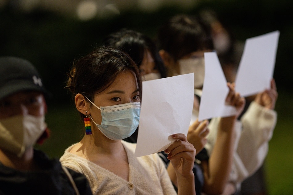 Mainland Chinese students hold sheets of blank paper during a vigil for the victims of China’s zero-COVID policy and the victims of the Urumqi fire at the University of Hong Kong in Hong Kong, China, 29 November 2022. Protests against China's strict COVID-19 restrictions have erupted in various cities including Beijing and Shanghai, triggered by a tower fire that killed 10 people in Xinjiang’s capital, Urumqi. EPA-EFE/JEROME FAVRE