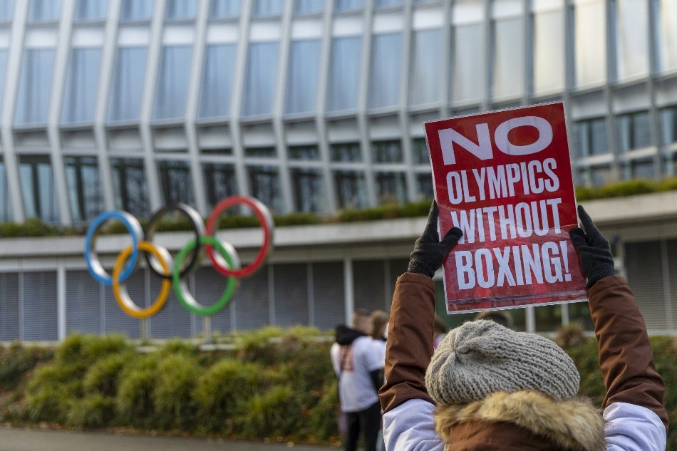 A woman holds a sign in support of boxing at the Olympics Games during the the Executive Board meeting of the International Olympic Committee (IOC) in Lausanne, Switzerland 05 December 2022. Denis Balibouse, EPA-EFE