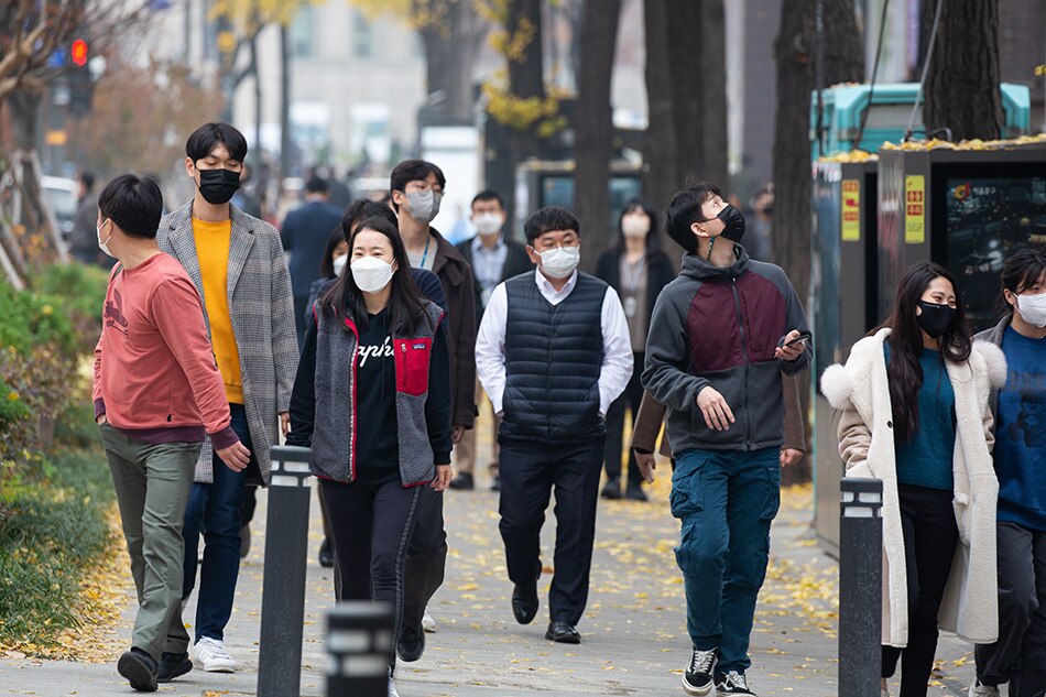 People wearing face masks walk on the street in Seoul, South Korea, Nov. 19 , 2021. Jeon Heon-Kyun, EPA-EFE/File 