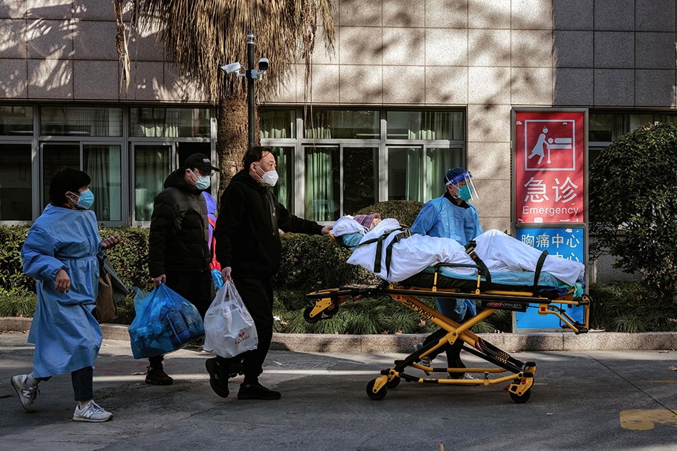 Health workers carry a person to the hospital, in Shanghai, China, Dec. 23, 2022. Alex Plavevski, EPA-EFE