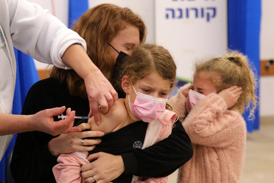 An Israeli health worker administers a dose of the Pfizer-BioNTech COVID-19 vaccine to a child at the Clalit Health Services in the central Israeli city of Modiin on Sunday. Gil Cohen-Magen, AFP