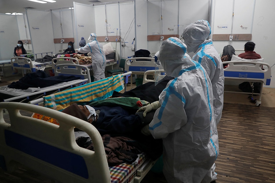 Medical workers wearing personal protective equipment (PPE) tend to a patient suffering from coronavirus disease (COVID-19), inside a care center at an indoor sports complex, amidst the spread of the disease, in New Delhi, India, January 5, 2022. Adnan Abidi, Reuters