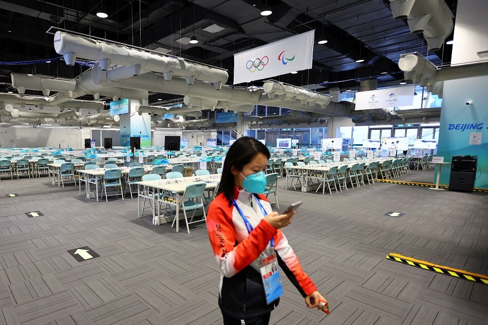A volunteers walks in a working area at the Main Press Centre ahead of the Beijing 2022 Winter Olympics in Beijing on January 6, 2022. Fabrizio Bensch, Reuters
