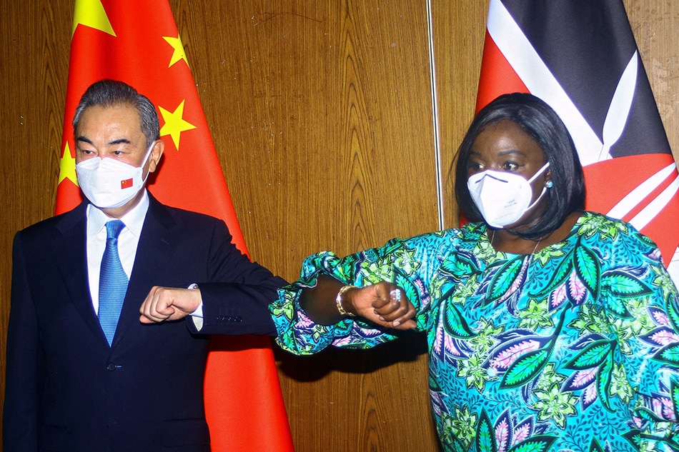 Chinese Foreign Minister Wang Yi and his Kenyan counterpart, Raychelle Omamo, bump elbows during a news conference in the coastal city of Mombasa, Kenya on January 6, 2022. Joseph Okanga, Reuters