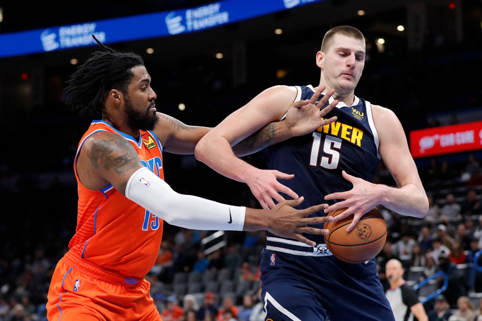Oklahoma City Thunder center Derrick Favors (15) and Denver Nuggets center Nikola Jokic (15) reach for a loose ball during the second half at Paycom Center. Alonzo Adams, USA TODAY Sports/Reuters.