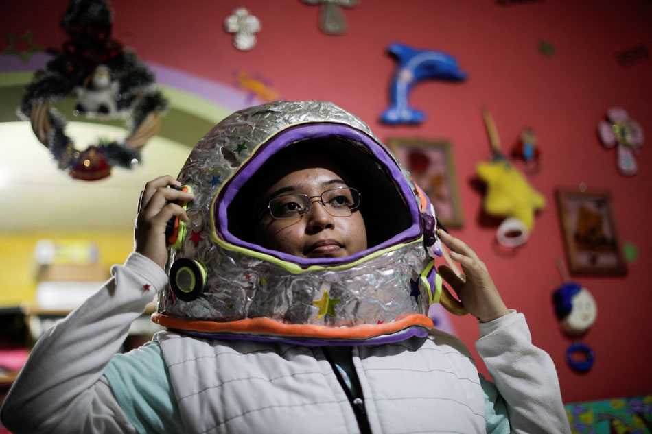 Guadalupe Estrella Salazar Calderon, 17, who is developing a sign-language translation app to connect Mexican Sign Language (MSL) speakers and interpreters with hearing users, poses with an astronaut helmet that she made, at her house in the municipality of Nezahualcoyotl, Mexico December 30, 2021. Luis Cortes, Reuters