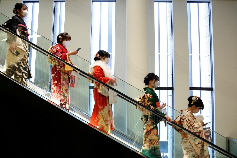 Women wearing kimono and protective masks ride on an escalator at Coming of Age Day celebration ceremony venue, amid the COVID-19 outbreak, in Tokyo on January 10, 2022. Kim Kyung-Hoon, Reuters