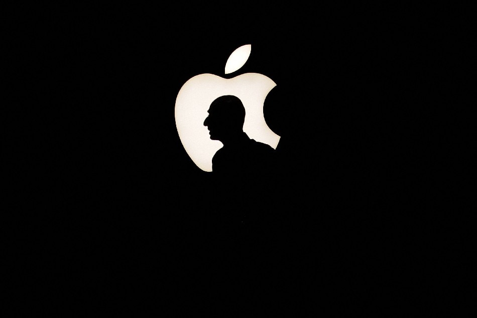 A man walks past a backlit Apple logo during an Apple media event in San Francisco, California, September 9, 2015. Beck Diefenbach, Reuters/File Photo