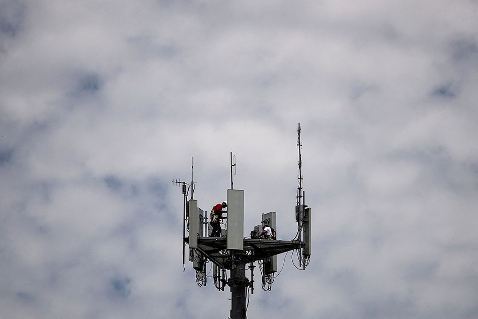 Workers install 5G telecommunications equipment on a T-Mobile US Inc tower in Seabrook, Texas, US May 6, 2020. Adrees Latif, Reuters/File Photo