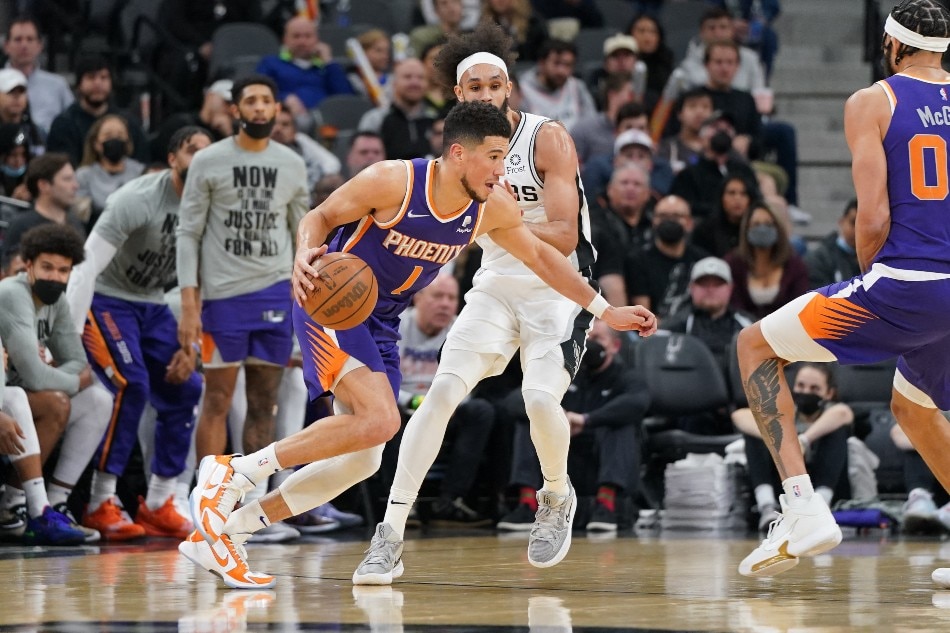 Phoenix Suns guard Devin Booker (1) dribbles against San Antonio Spurs guard Derrick White (4) in the second half at the AT&T Center. Daniel Dunn, USA TODAY Sports/Reuters.