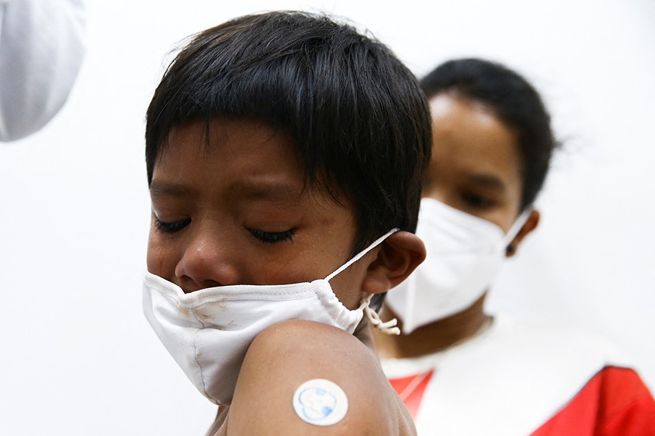 An indigenous child named Stevon Tataendy, 8, reacts after receiving a dose of Pfizer-BioNTech coronavirus disease (COVID-19) paediatric vaccine in Sao Paulo, Brazil January 17, 2022. Picture taken January 17, 2022. Carla Carniel, Reuters