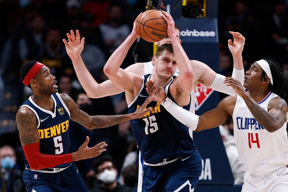 Denver Nuggets center Nikola Jokic (15) grabs a rebound against Los Angeles Clippers guard Terance Mann (14) as forward Will Barton (5) defends in overtime at Ball Arena. Isaiah J. Downing, USA TODAY Sports/Reuters