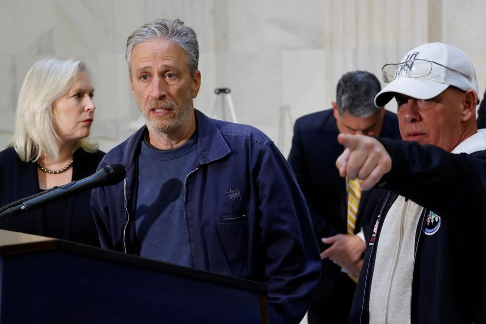 Comedian Jon Stewart, with U.S. Senator Kirsten Gillibrand (D-NY) and John Feal, an advocate for first responders, speaks to reporters about their effort to raise awareness for U.S. veterans suffering from illnesses caused by military toxic exposures during a news conference on Capitol Hill in Washington, U.S. November 4, 2021. REUTERS/Jonathan Ernst