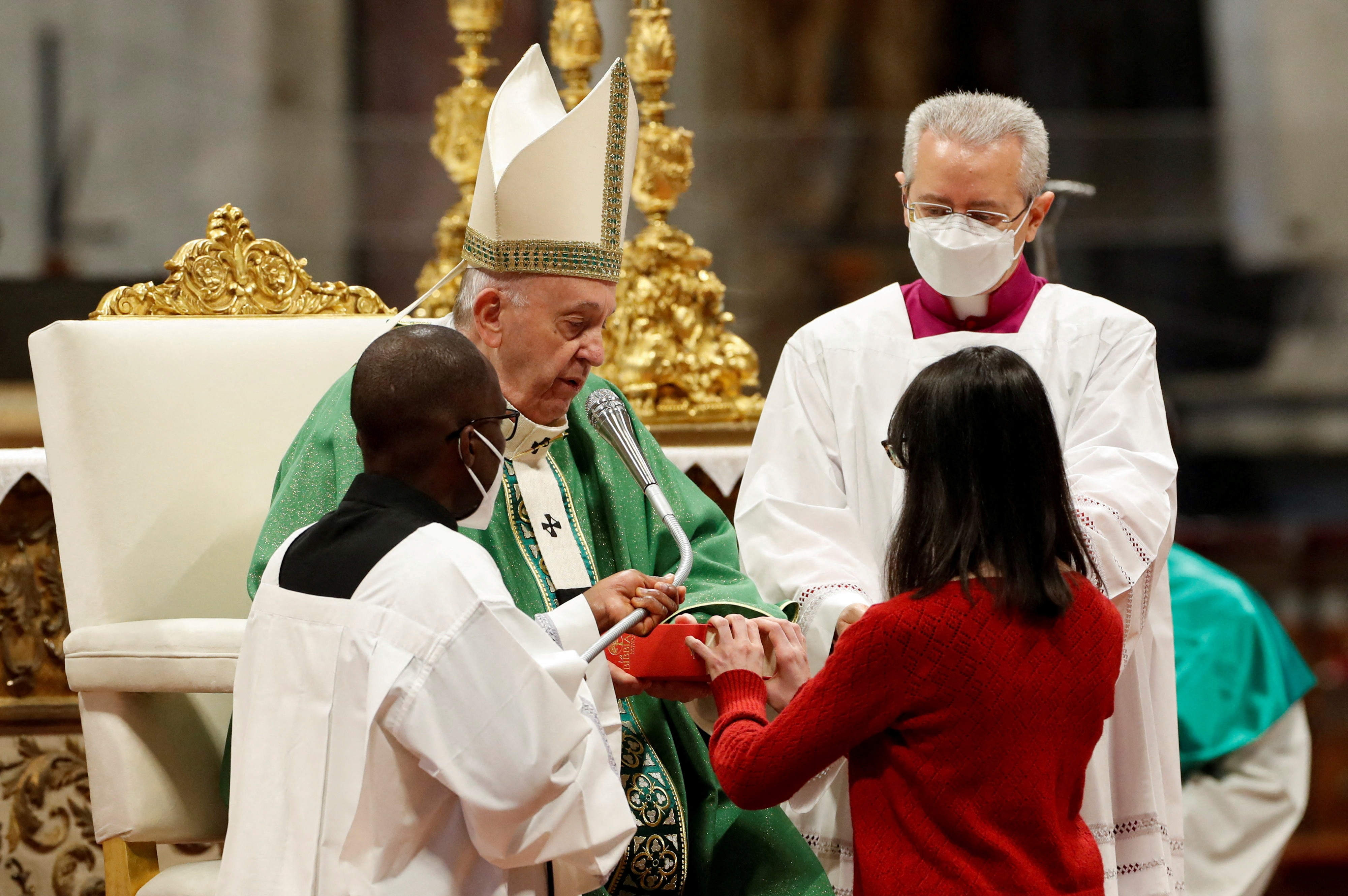 A new lector receives a gospel from Pope Francis during a Holy Mass held every year on the third Sunday of January to celebrate and study the Word of God, in St. Peter's Basilica at the Vatican, January 23, 2022. Remo Casilli, Reuters