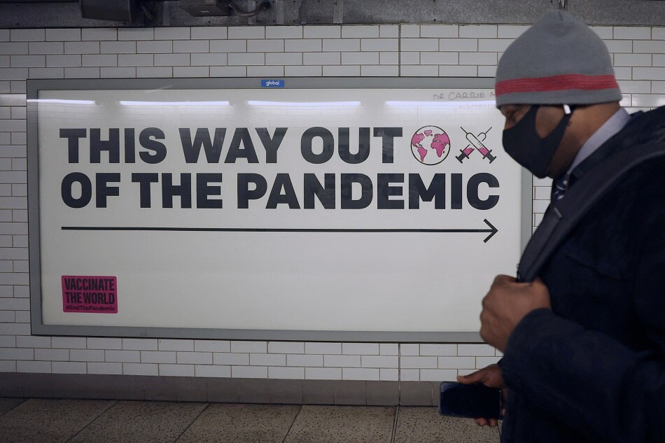 A man walks past a sign amidst the spread of the coronavirus disease in London, January 24, 2022. Hannah McKay, Reuters
